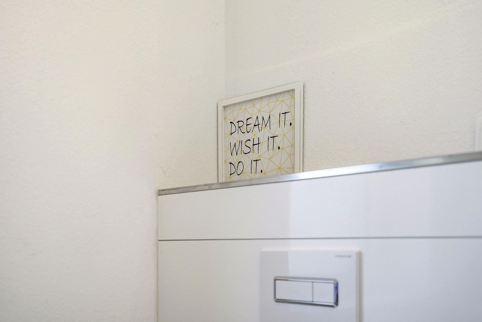 Wall with picture: DREAM IT. WISH IT. DO IT. and switch.