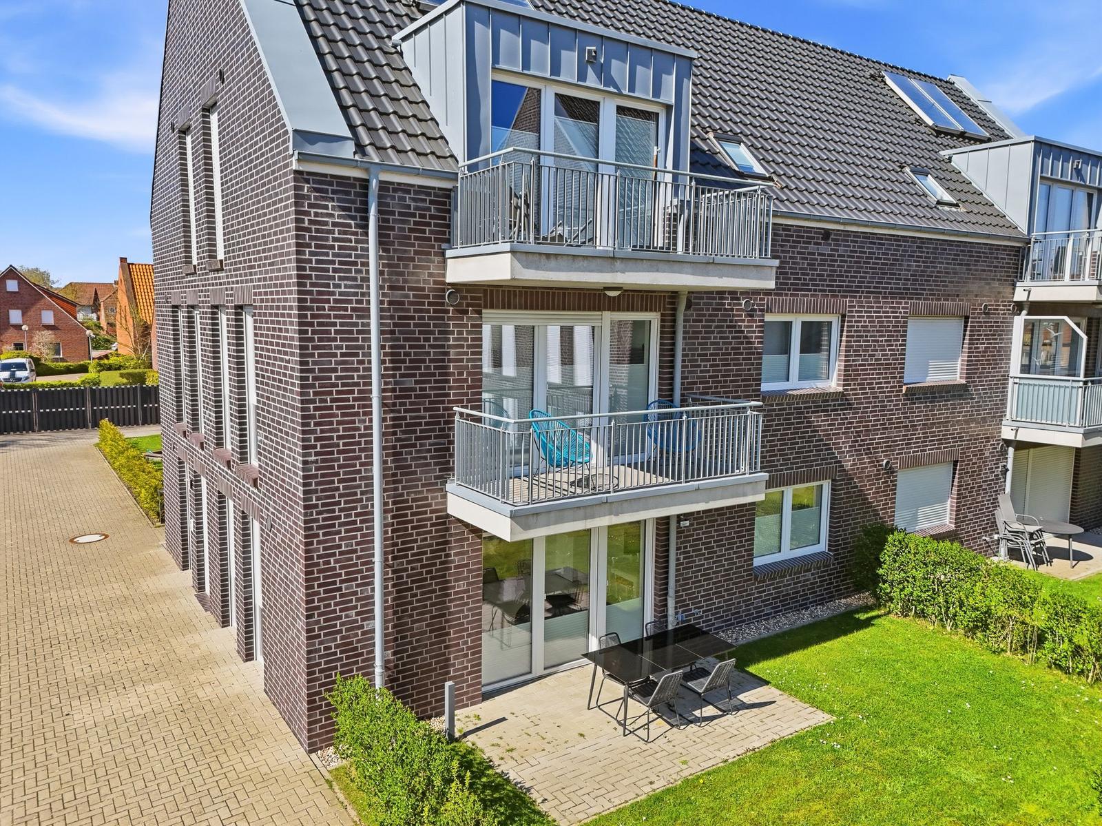 Modern multi-family house with balconies and terrace with garden.