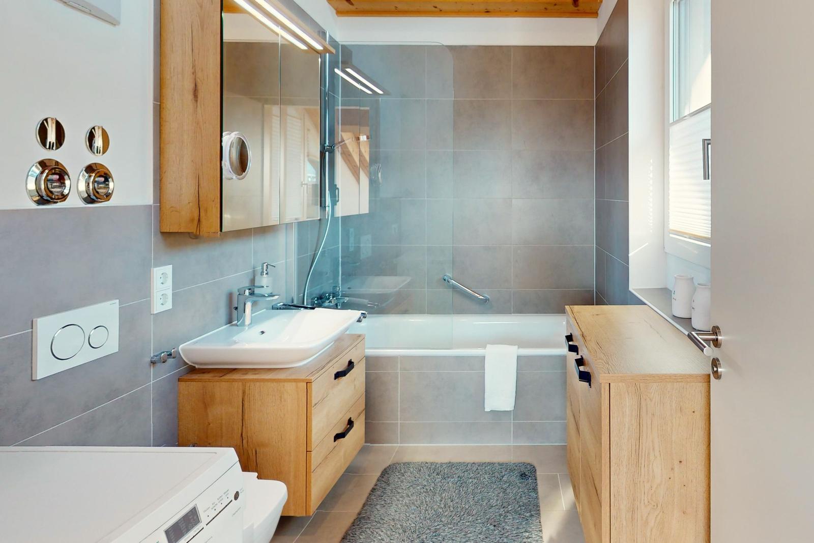 Bad mit Dusche, Waschbecken und Holzmöbel