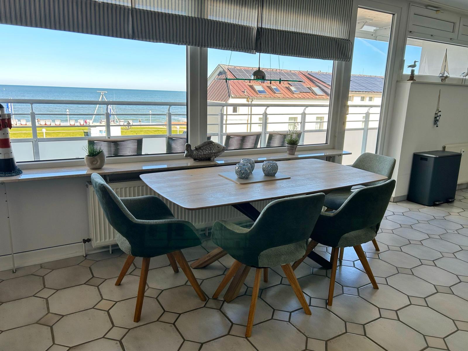 Essbereich mit Tisch und Stühlen. Blick auf das Meer und Strand.