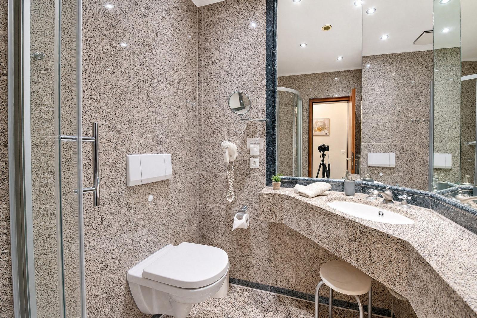 Bad mit Dusche, WC und Waschbecken aus Marmor