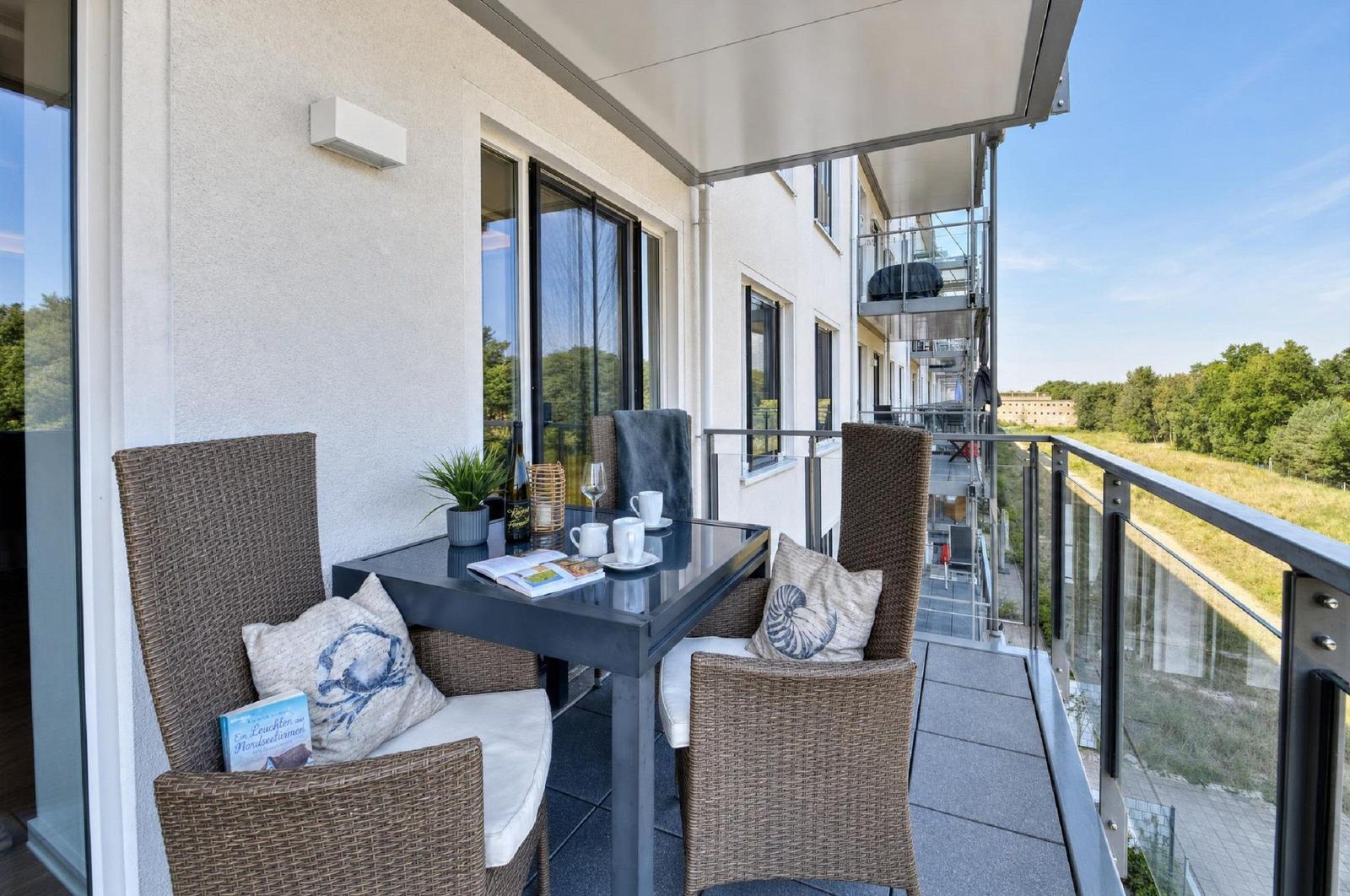 Terrasse mit Tisch, Stühlen und Sicht auf Grünland.