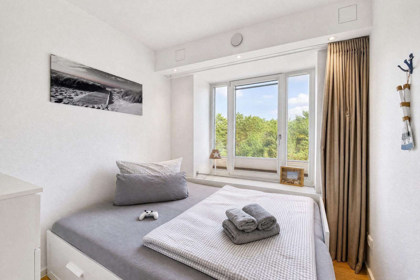 Schlafzimmer mit Bett, Fenster und Wandbild