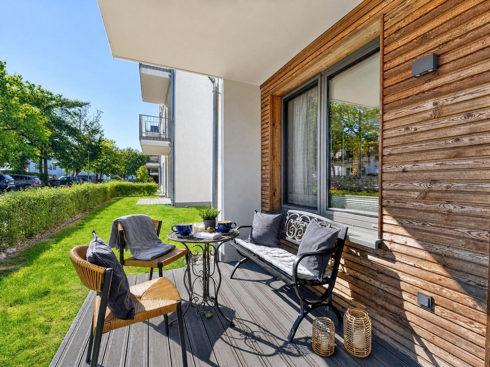 Terrace with seating and view of green lawn area.