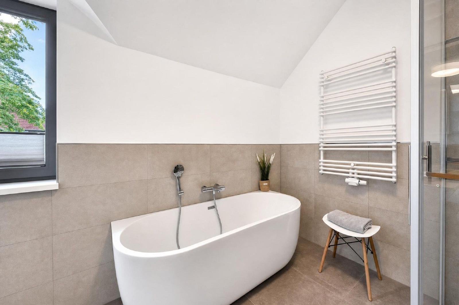 Bad mit freistehender Badewanne, Fenster und Heizkörper