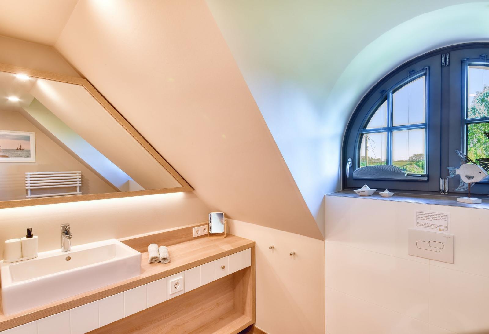 Dusche mit Holzregal und Fenster mit Blick nach draußen.