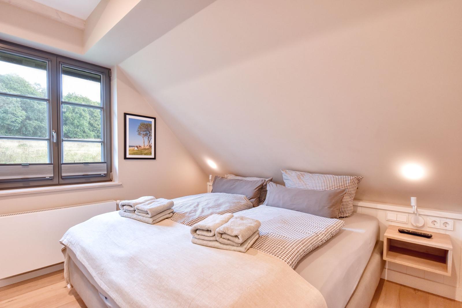 Schlafzimmer mit Doppelbett, Fenster und Nachttisch