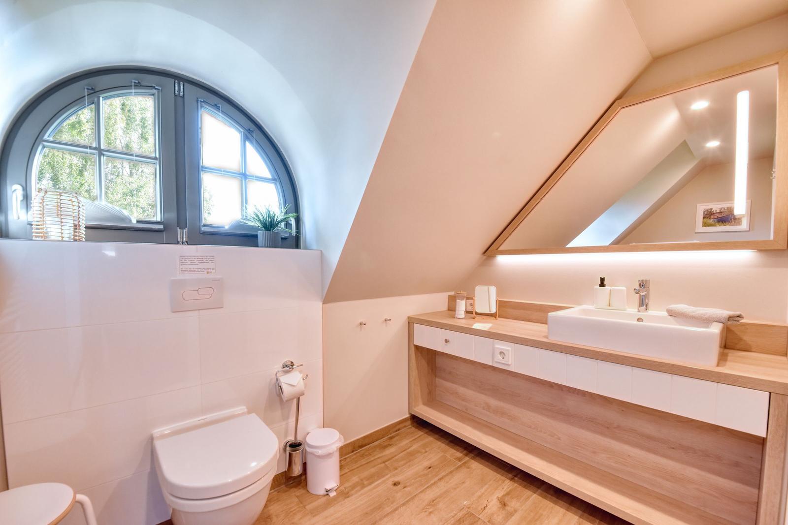 Badezimmer mit Dachschrägen, Waschtisch und Badezimmerfenster