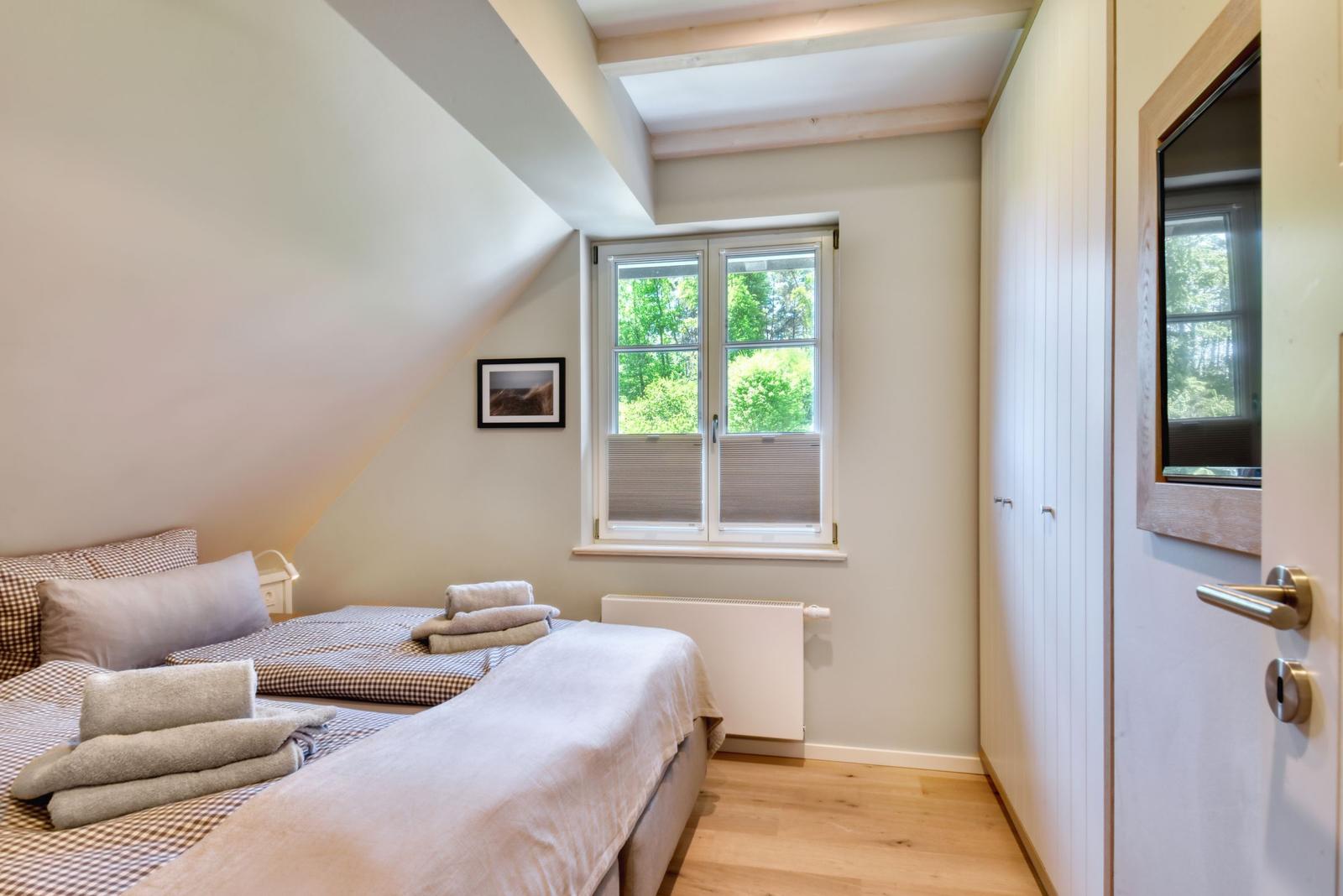 Schlafzimmer mit Doppelbett, Fenster und Kleiderschrank