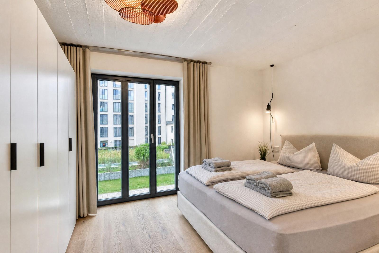 Schlafzimmer mit Doppelbett, Fenster und Holzboden.
