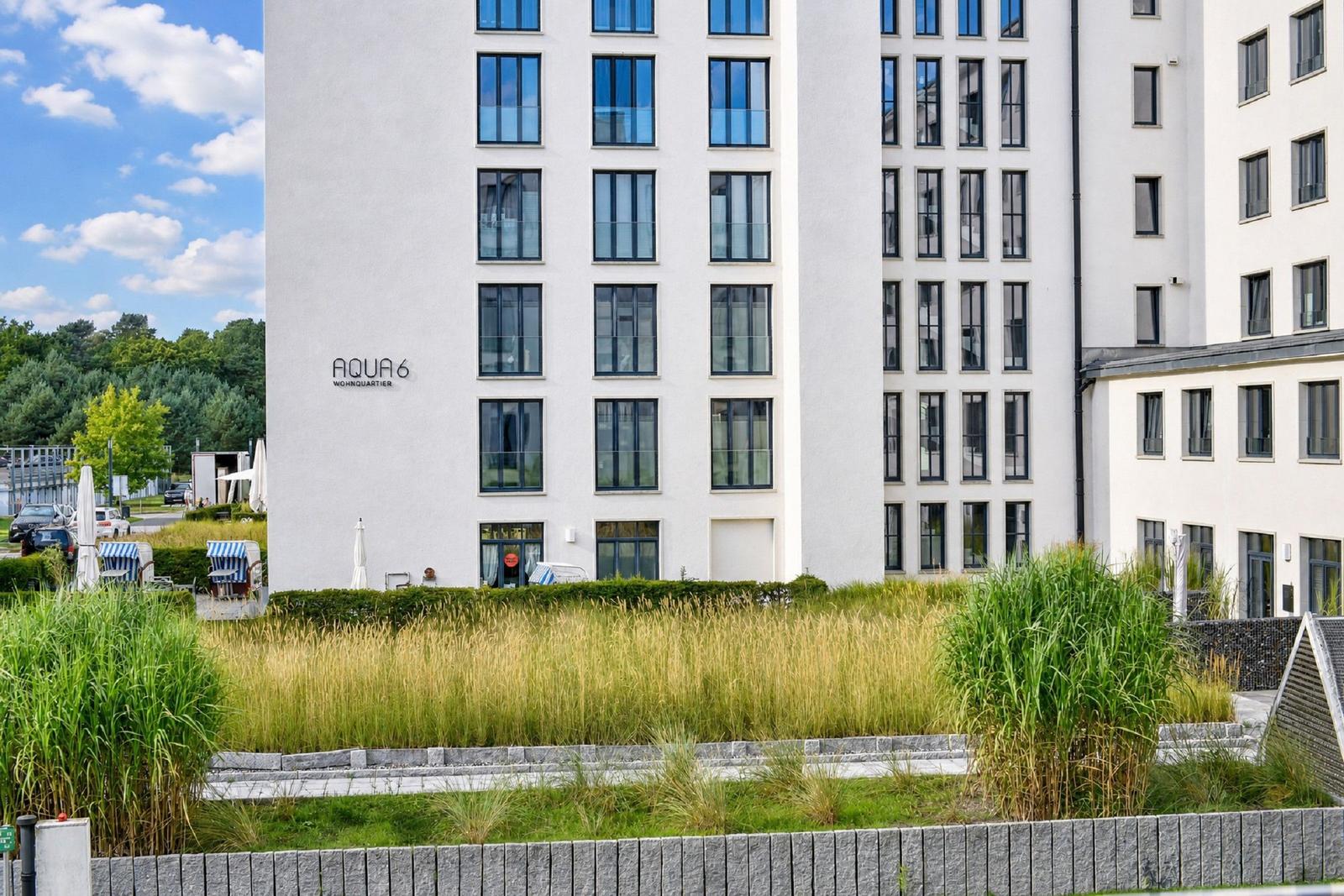 Modernes Wohnhaus mit großzügigen Fenstern und grüner Außenanlage.