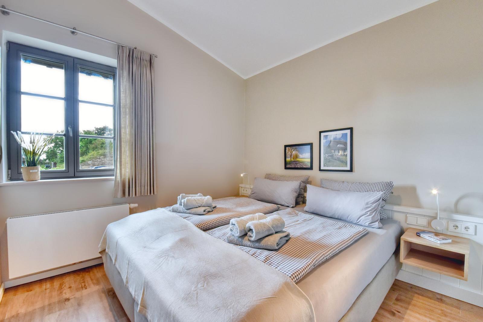 Schlafzimmer mit Doppelbett, Fenster und Nachttisch