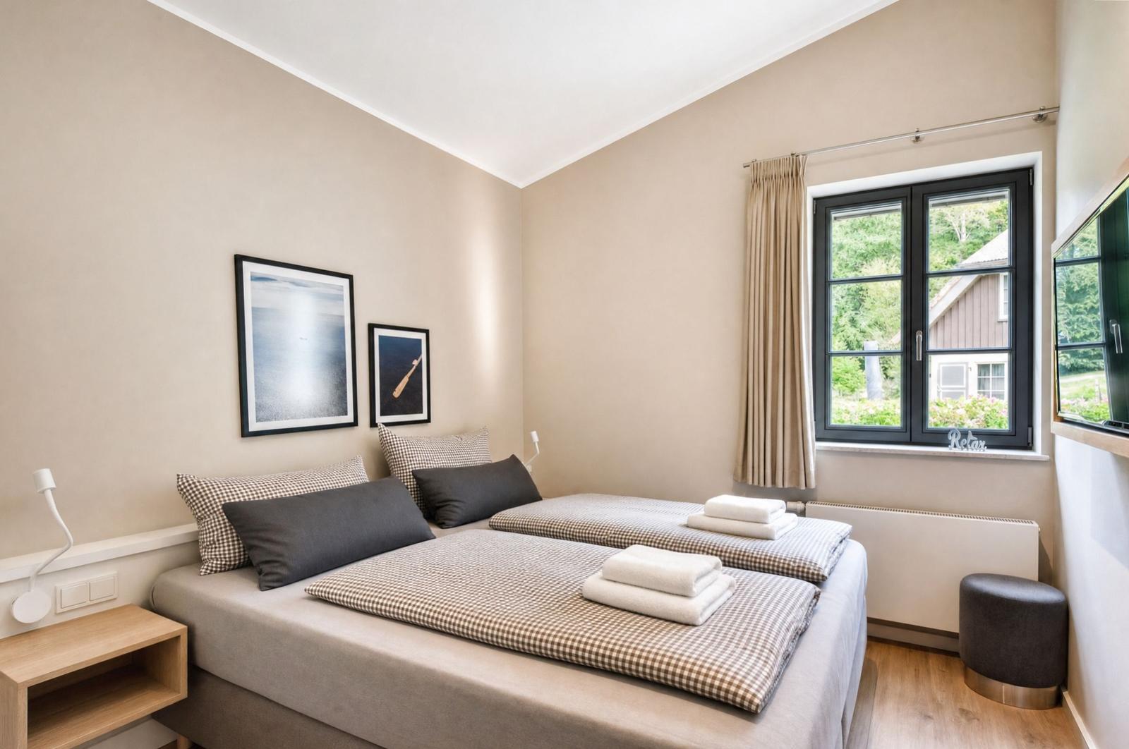 Zimmer mit Doppelbett, Fenster und Wandbildern