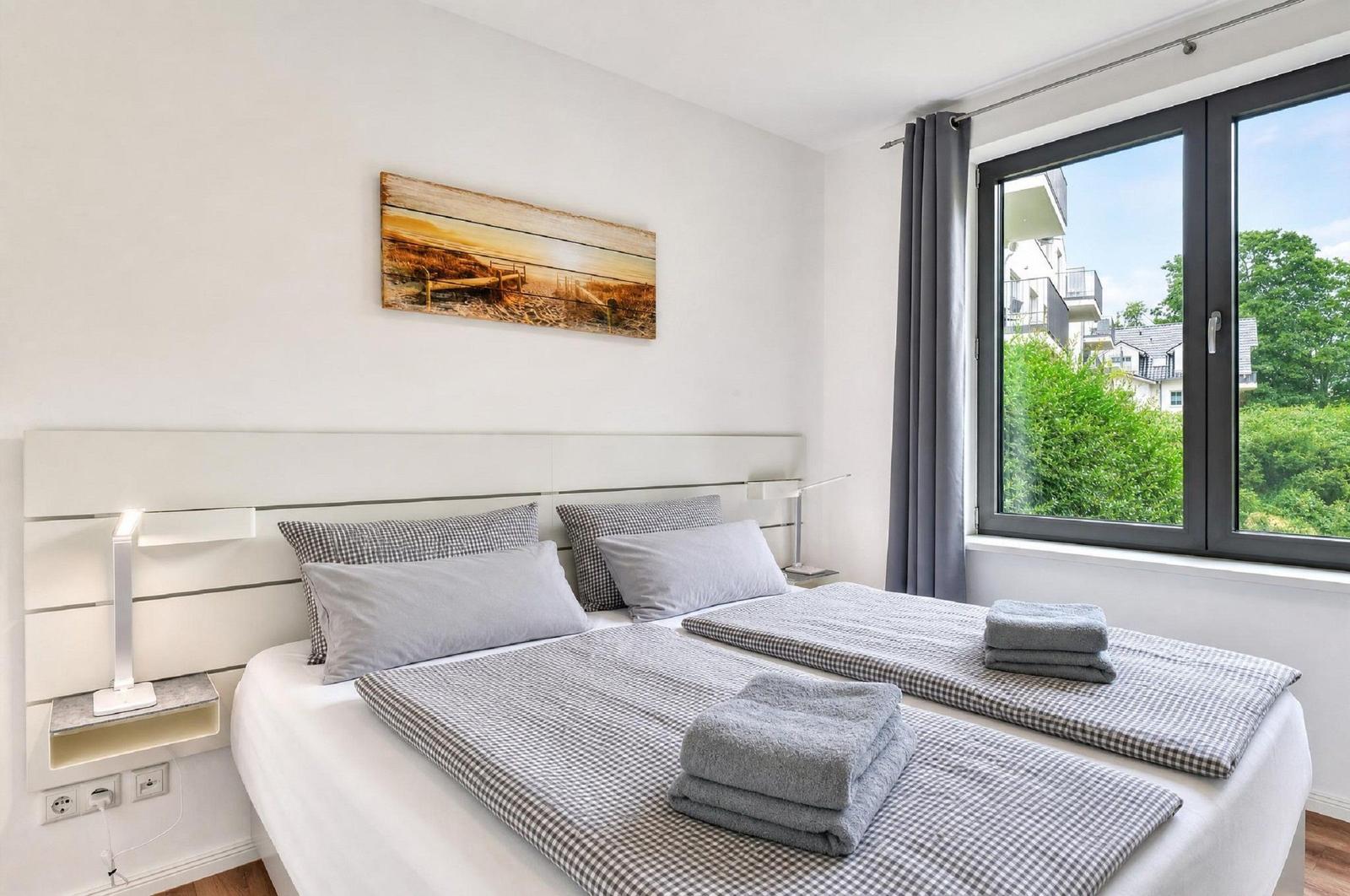 Schlafzimmer mit Doppelbett, Fensterblick und Wandbild