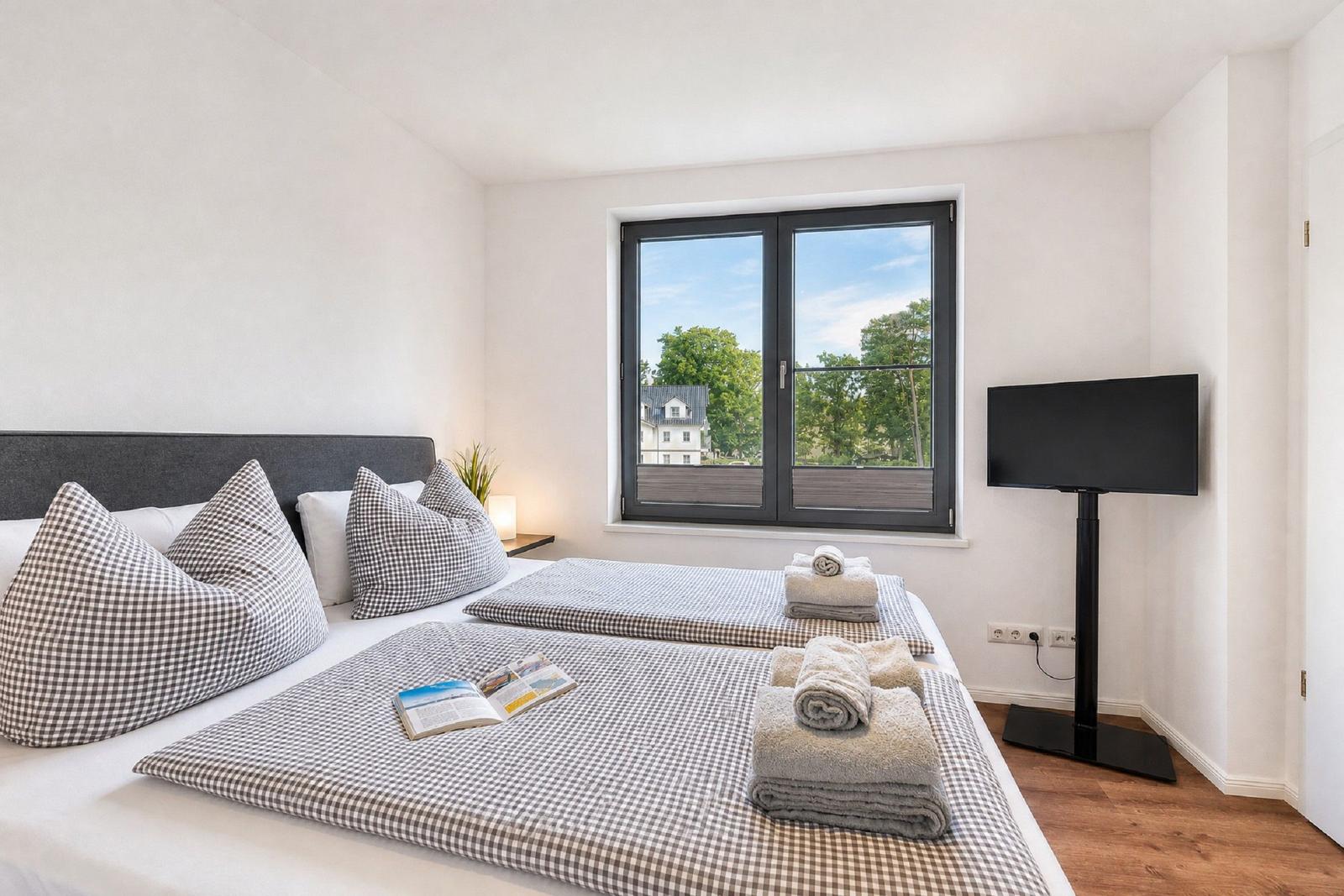 Doppelbett mit Kissen, Fensterblick und Fernseher