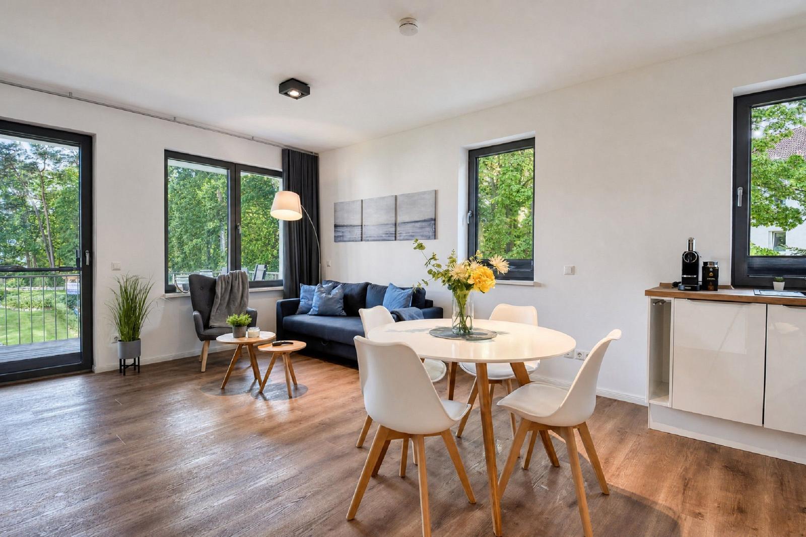 Wohn- und Essbereich mit Esstisch, Sofa und Blick auf Grün