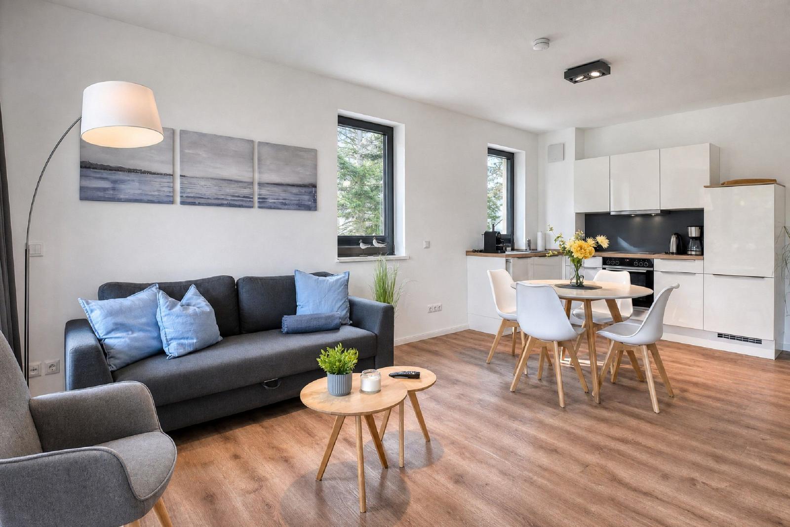 Wohn- und Essbereich mit Sofa, Tisch und Küche.