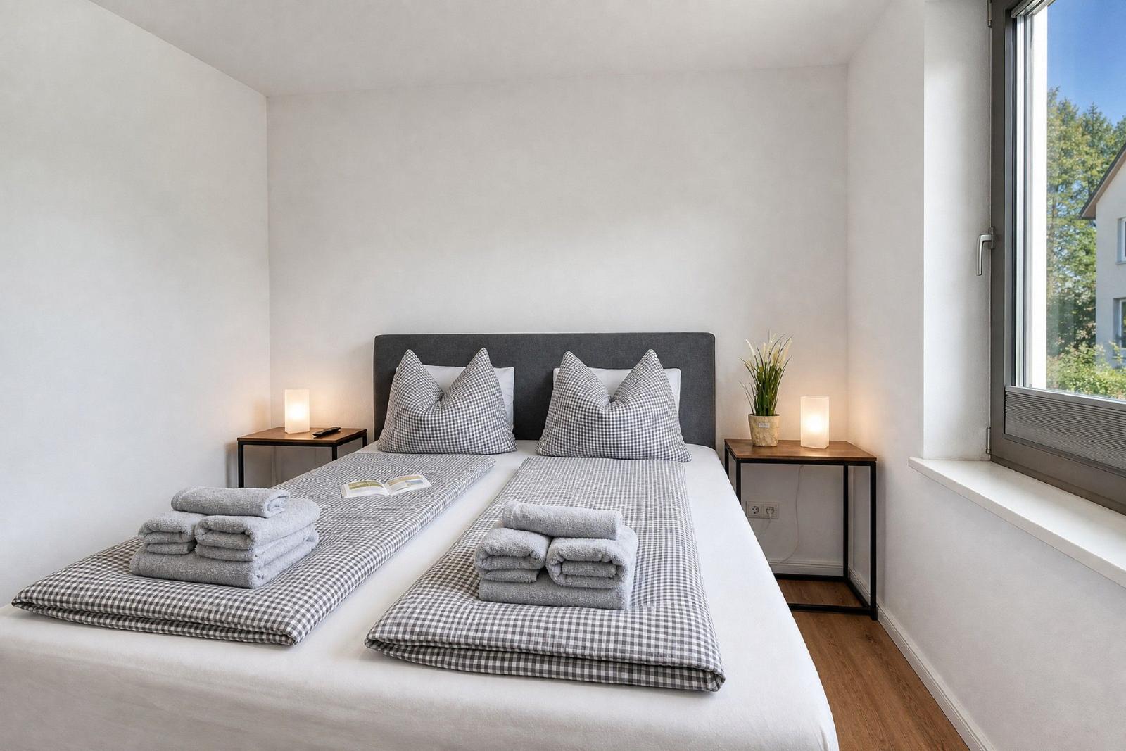 Schlafzimmer mit Doppelbett, zwei Nachttischen und Fensterblick.