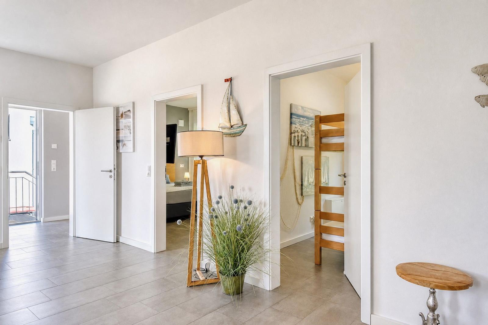 Haus mit Wohnbereich, Schlafzimmer und Balkon. Holzstühle und Wanddekoration.