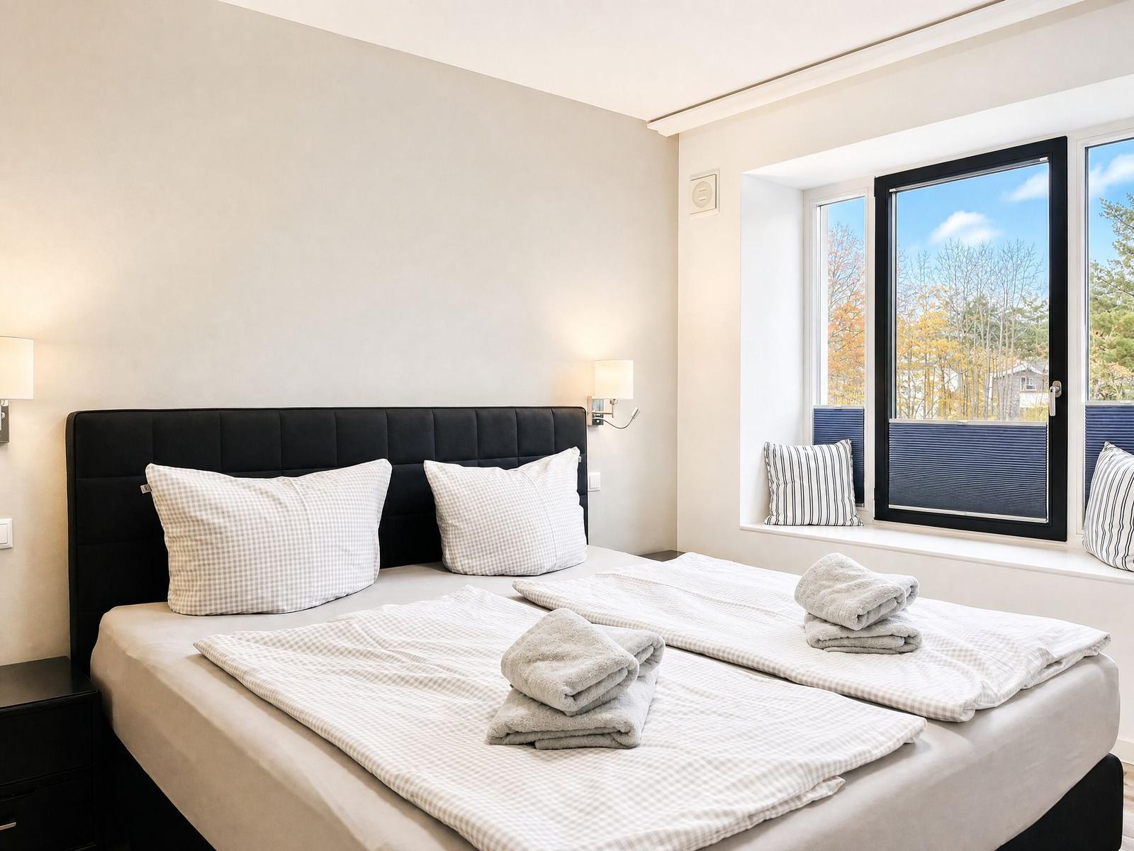 Bedroom with double bed, window, and bedding.