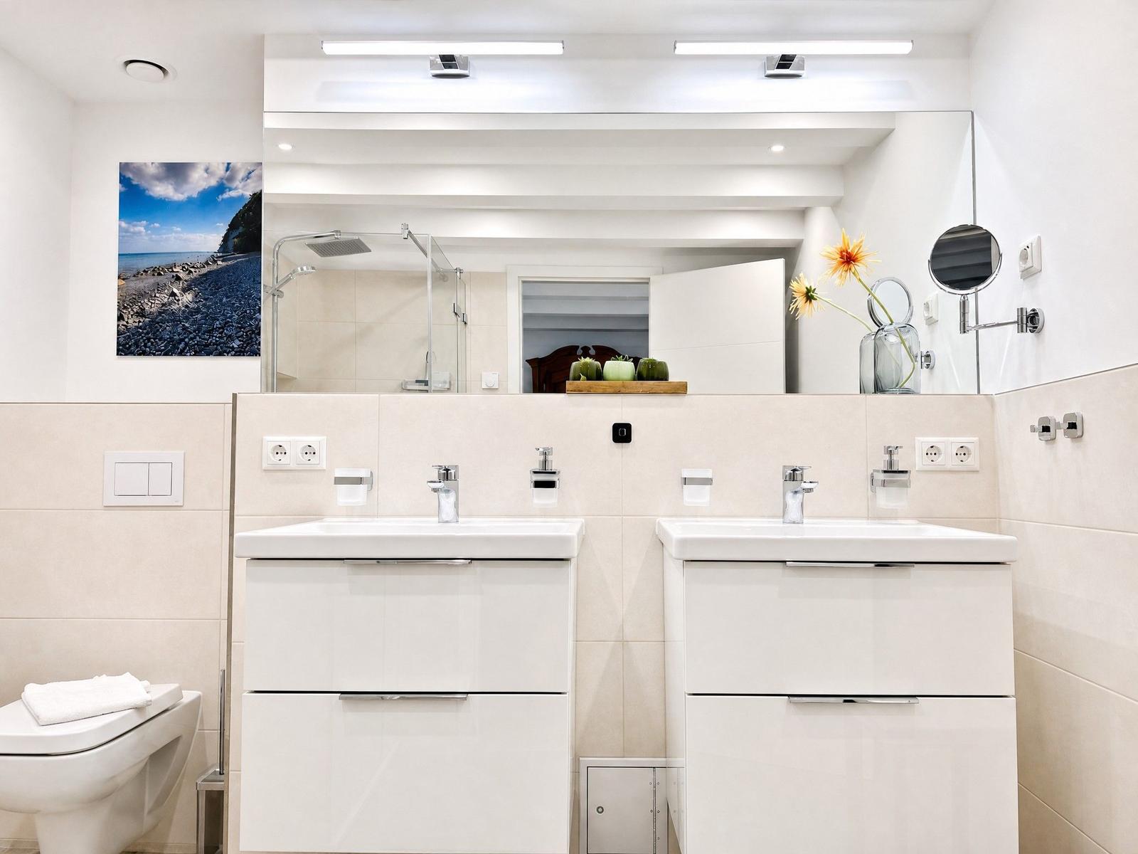 Badezimmer mit zwei Waschbecken, Spiegel und Dusche