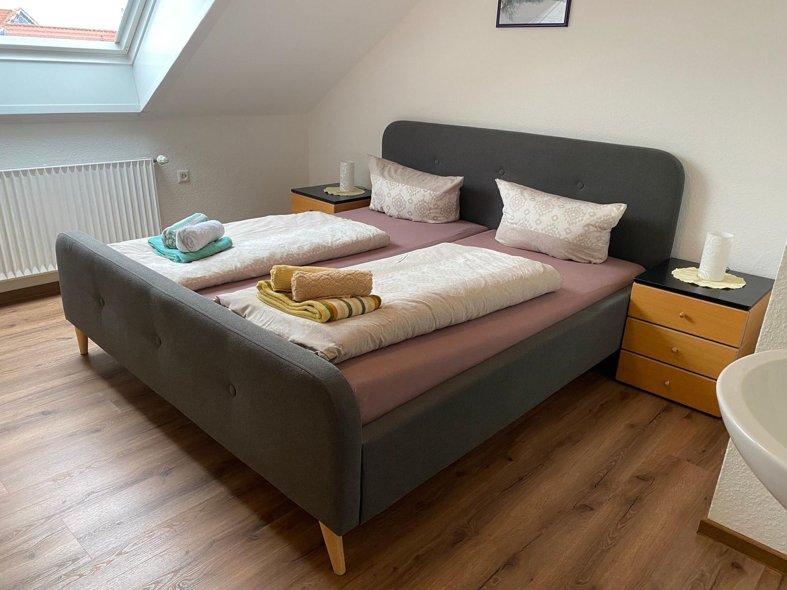 Schlafzimmer mit Doppelbett, zwei Nachttischen und Dachfenster.