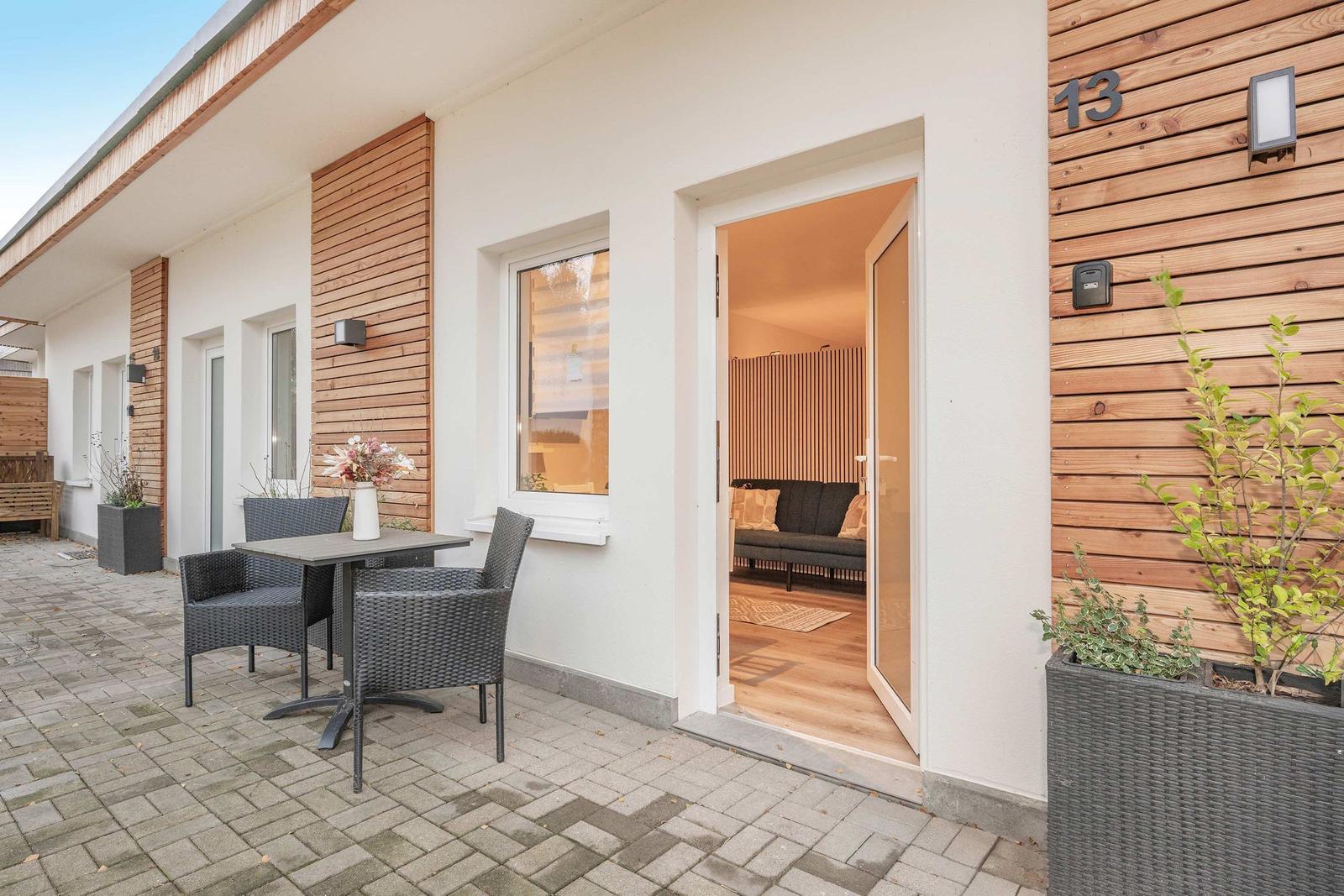 Entrance area with terrace, table, chairs, and view into the living room.