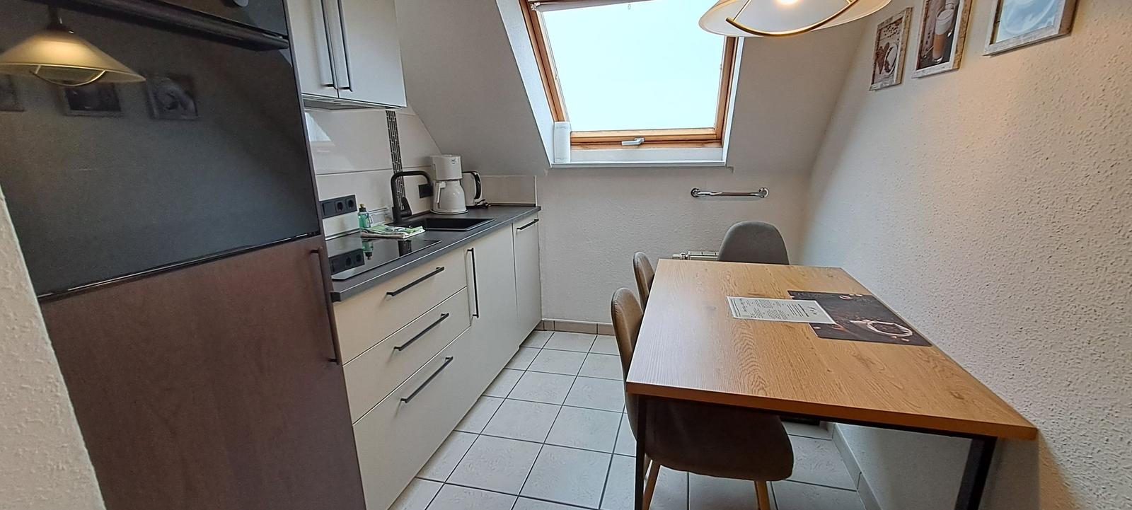 Küche mit Essbereich, Dachfenster und Küchenschränken.