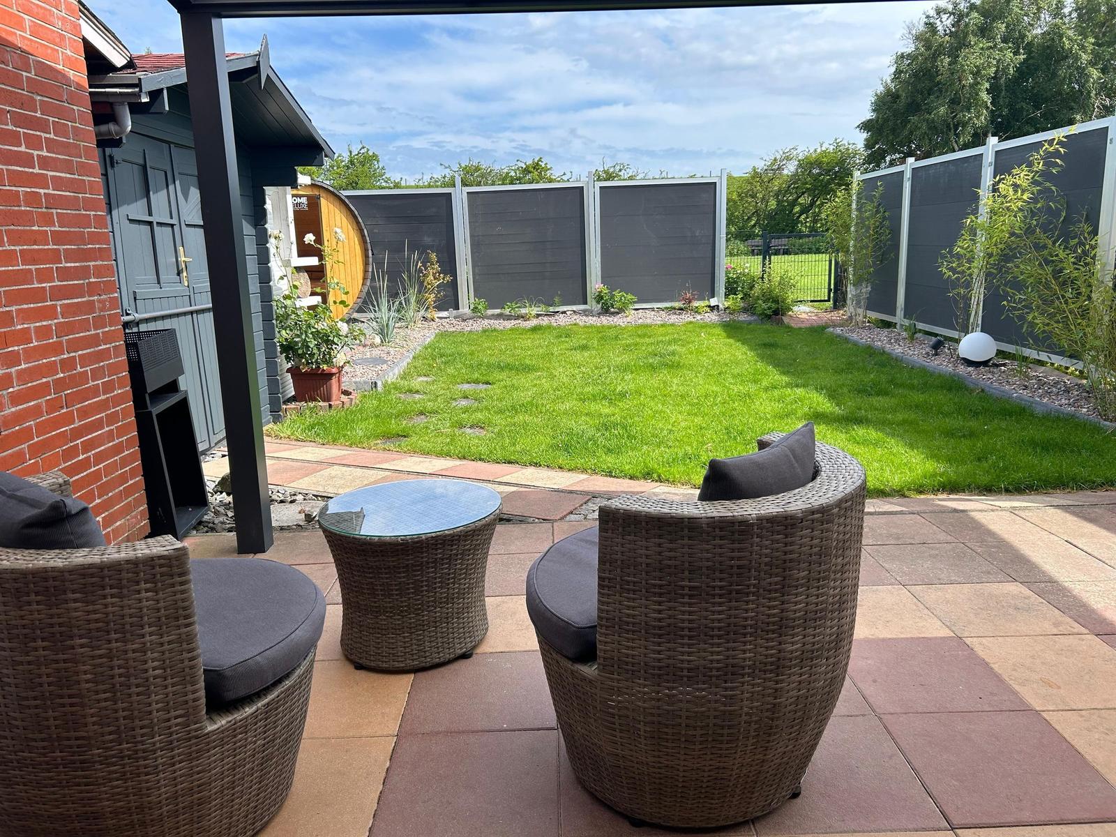 Hinterhof mit Garten, Terrasse und Sitzgelegenheiten.