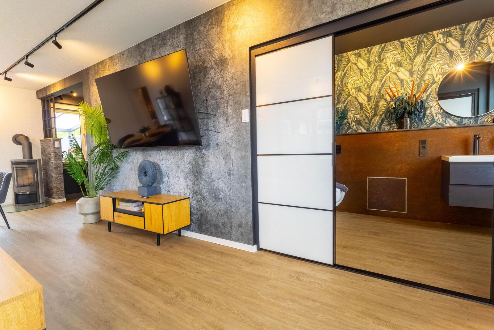 Moderne Wohnung mit Wohnbereich, Fernseher und Schlafzimmer mit Duschbad.