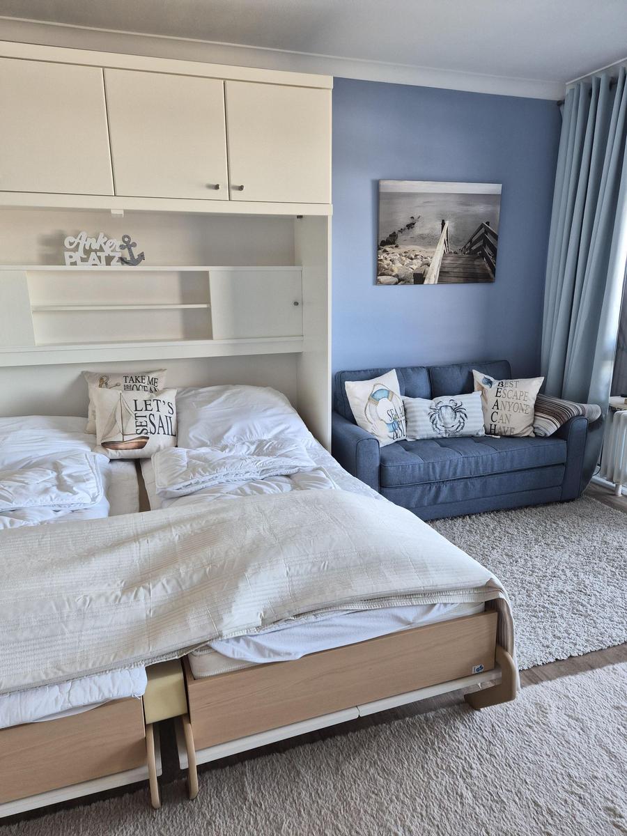 Bedroom with bed, sofa, and wall art