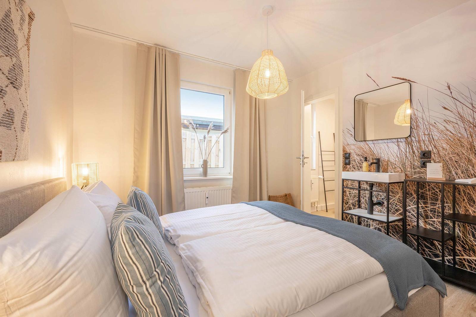 Schlafzimmer mit Doppelbett, Fenster und Badezimmer