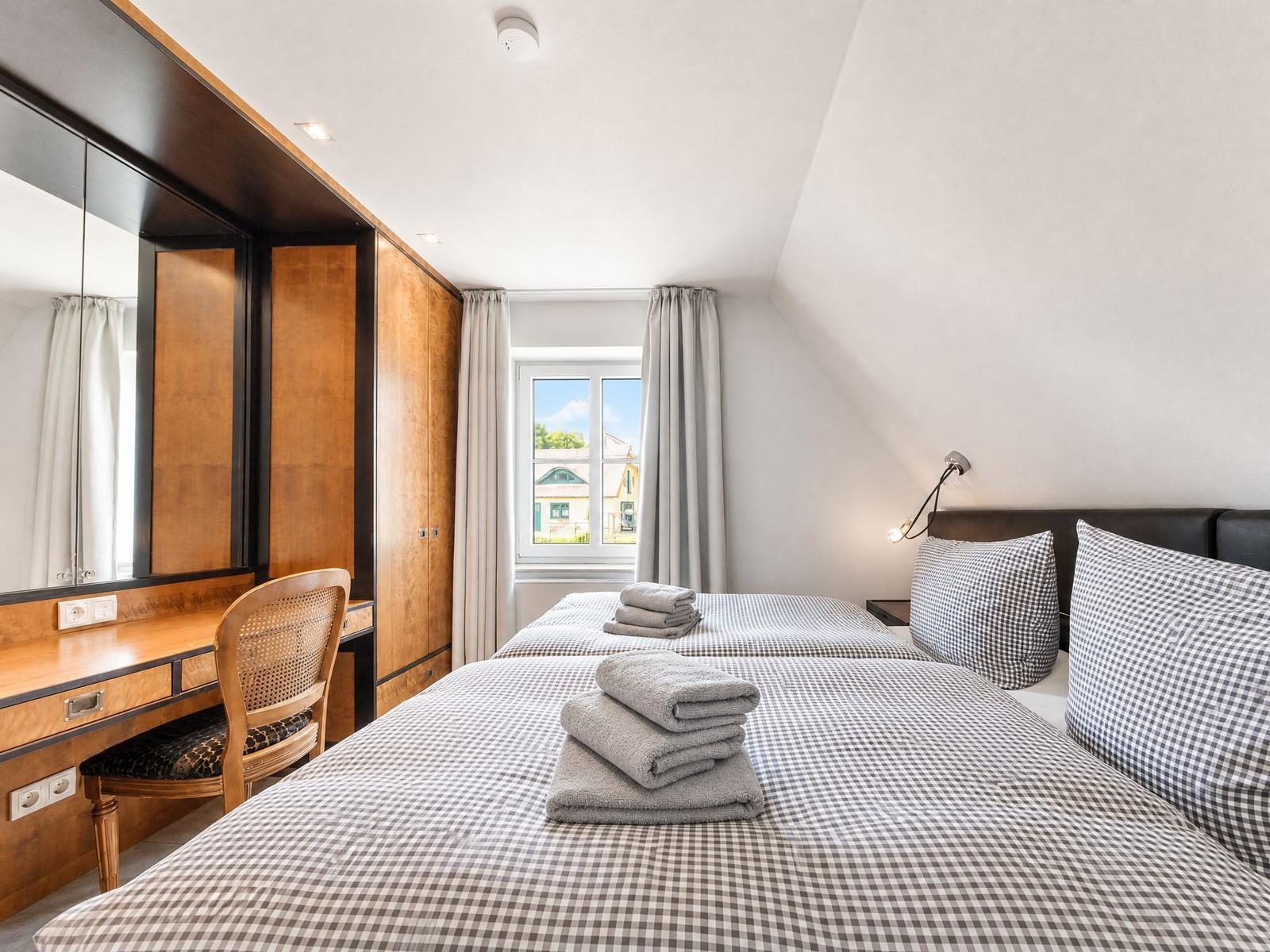 Schlafzimmer mit Doppelbett, Schreibtisch und Fenster mit Blick.