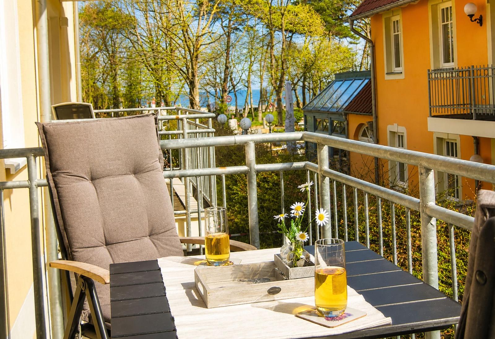 Terrasse mit Stuhl, Tisch und Blick auf den Strand.