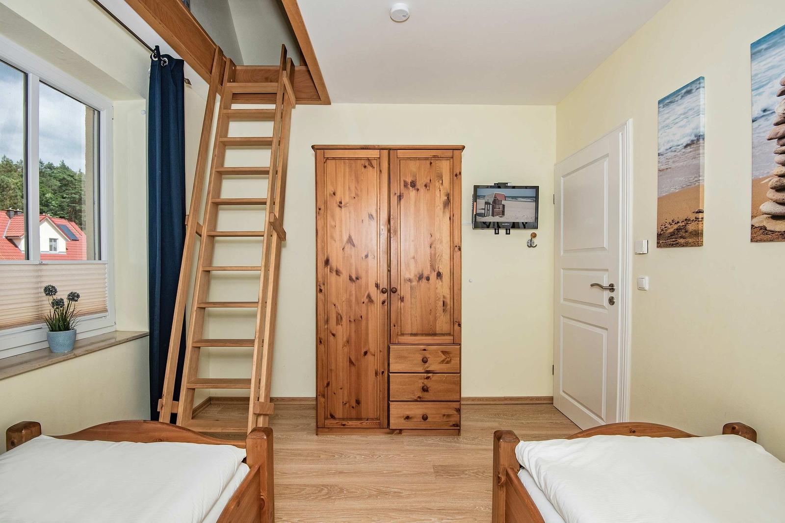 Zwei Betten, Holzschrank, Leiter zu Dachboden, Fenster mit Blick