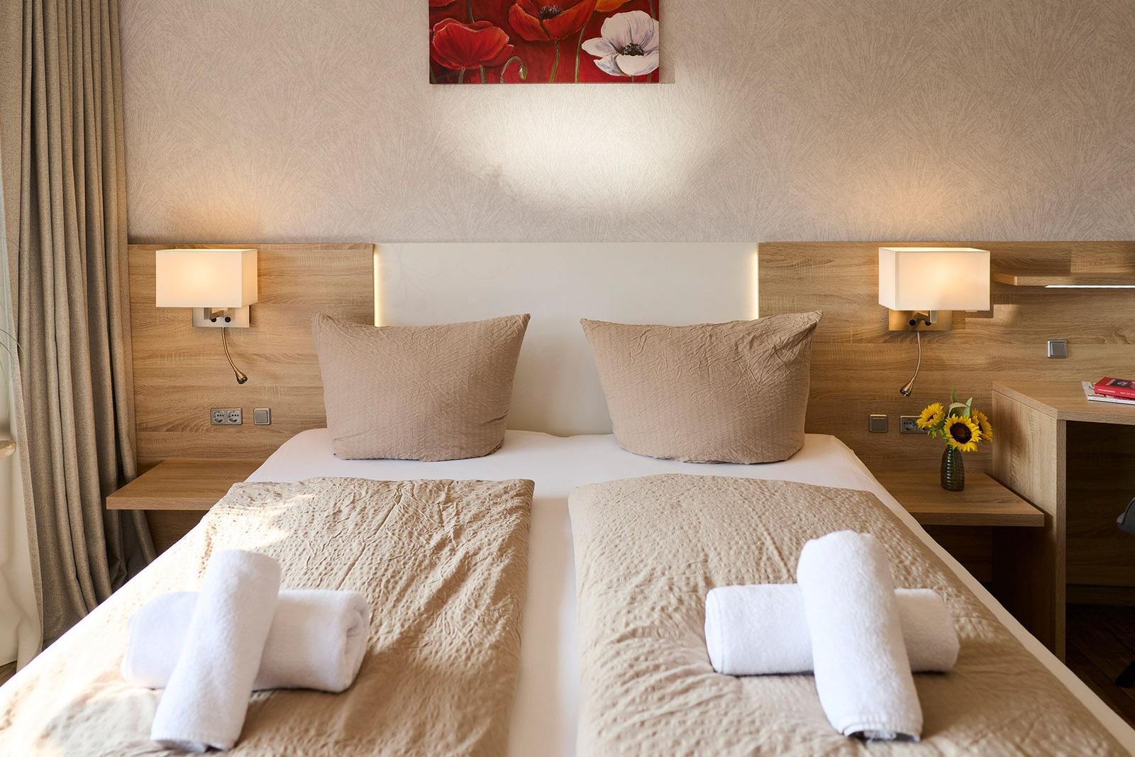 Double bed with two pillows, two nightstands, and wall decor.