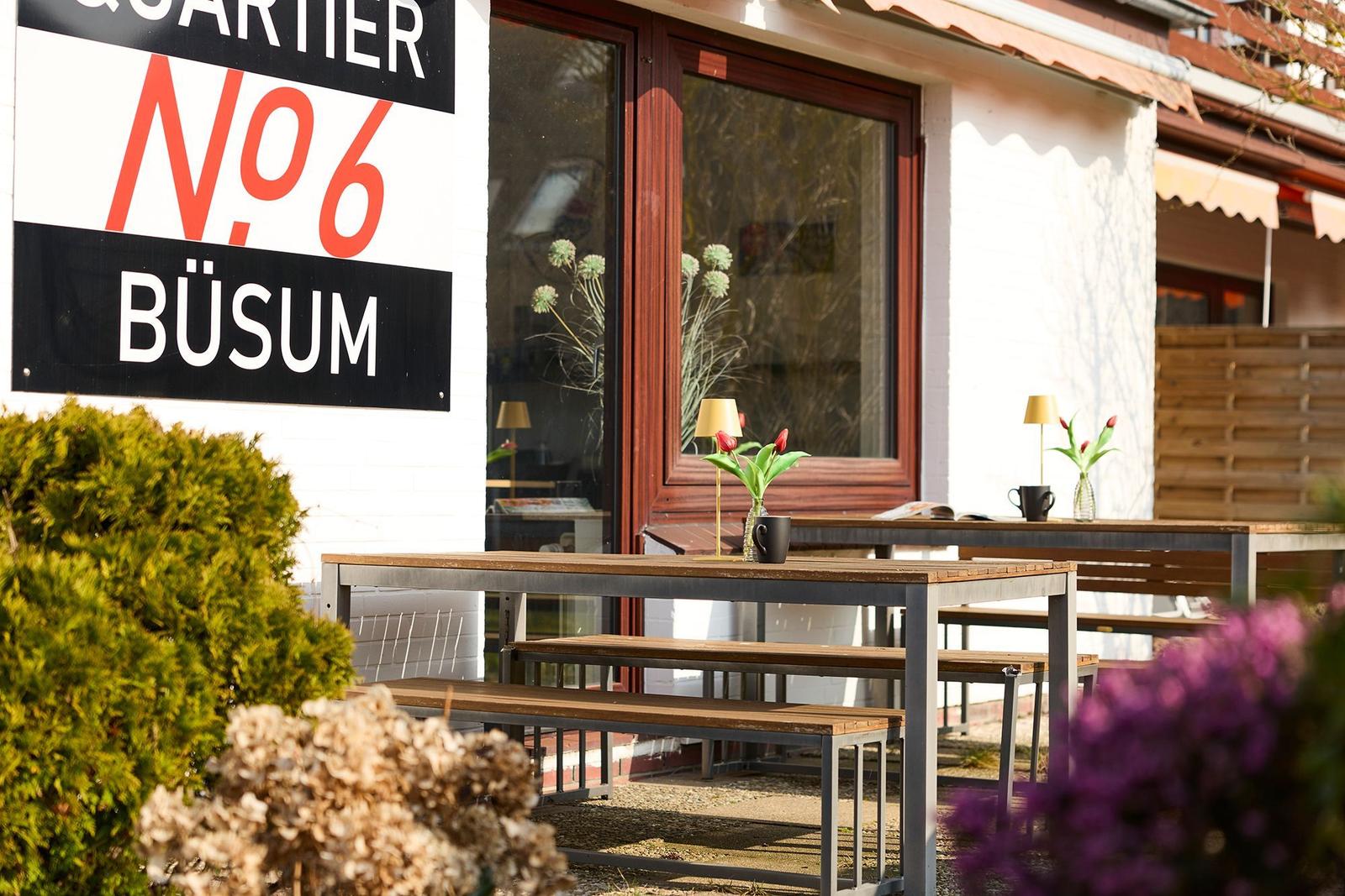 Outdoor area with table and benches in front of a house in Büsum.
