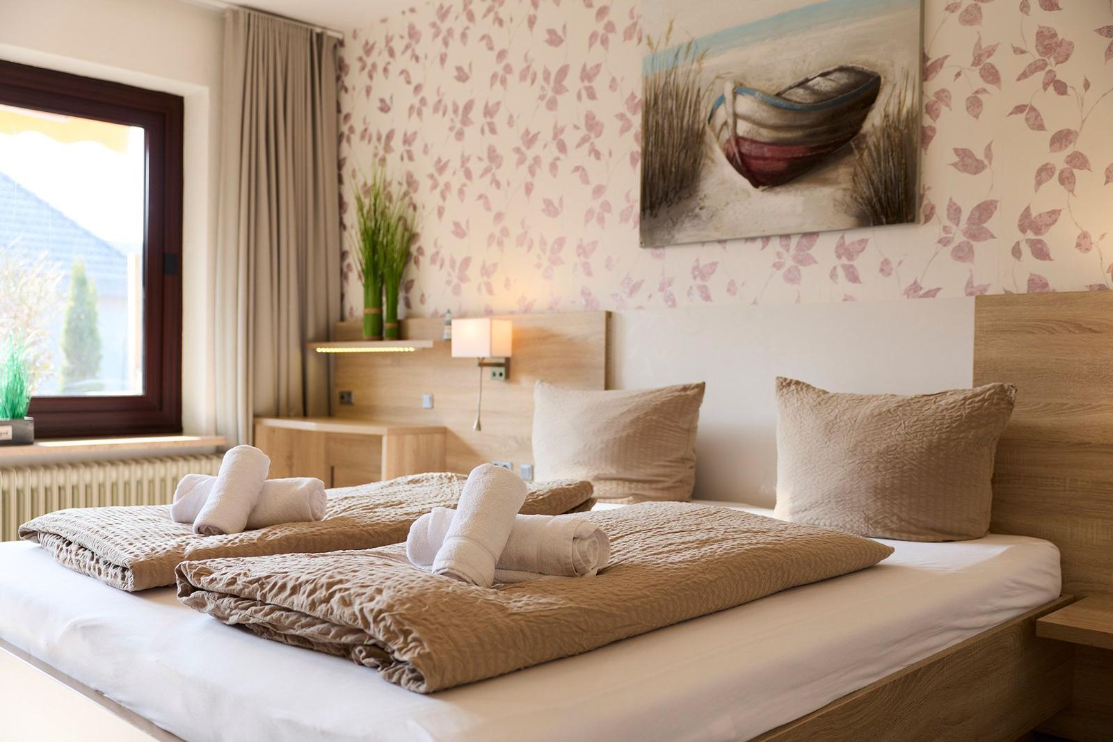 Ein Schlafzimmer mit einem Bett, einem Fenster und einer Wanddekoration.