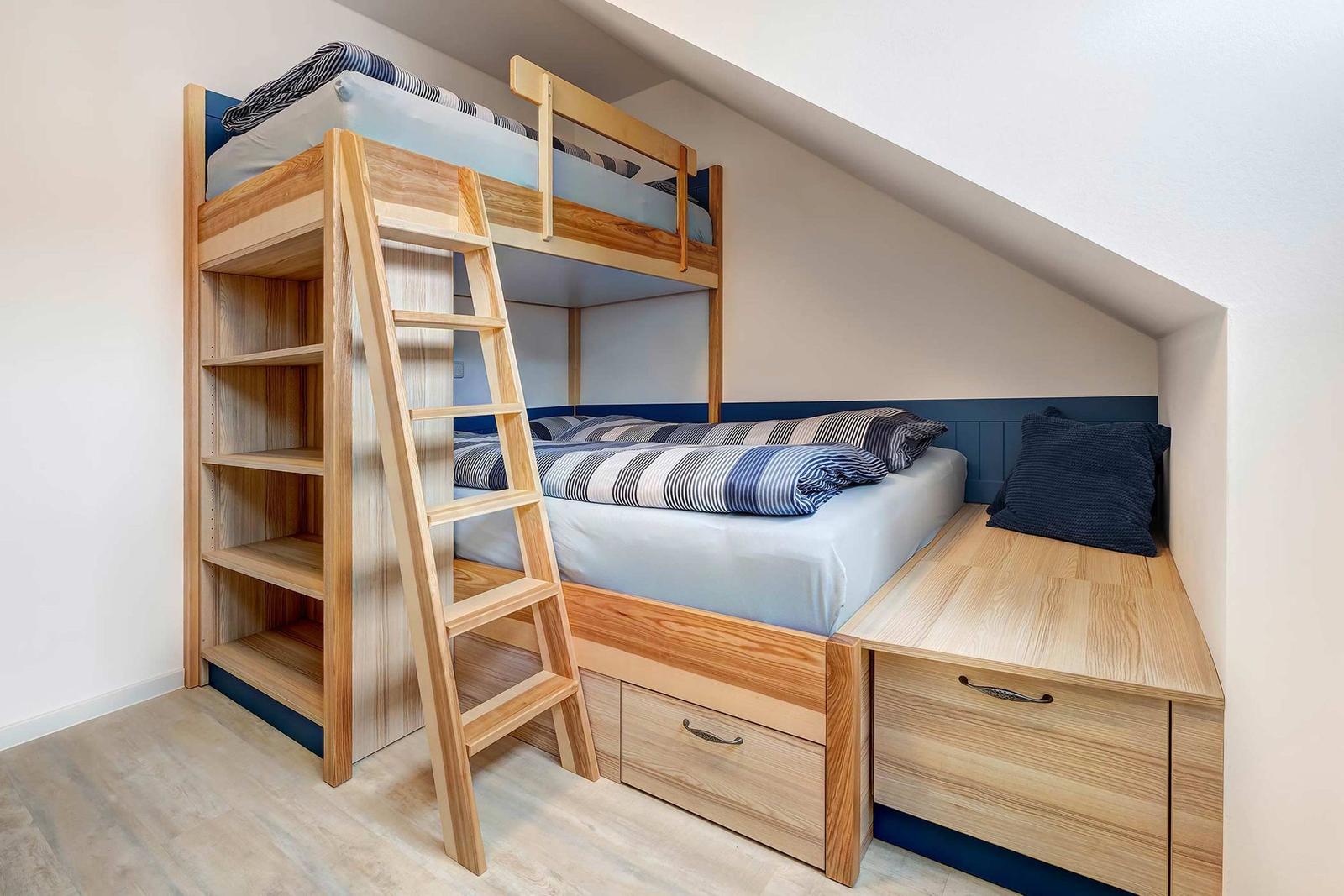 Doppelstockbett mit integriertem Schrank und Stauraum unterhalb des unteren Bettes.