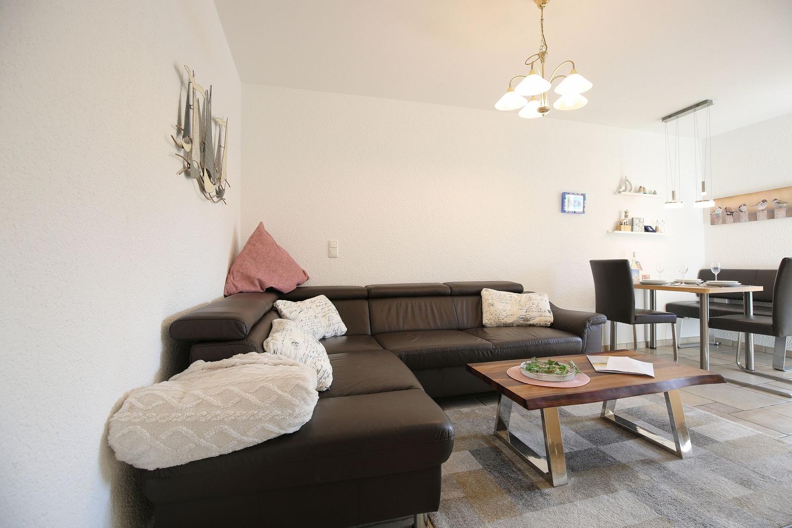 Living and dining area with brown sofa, table, and chairs.