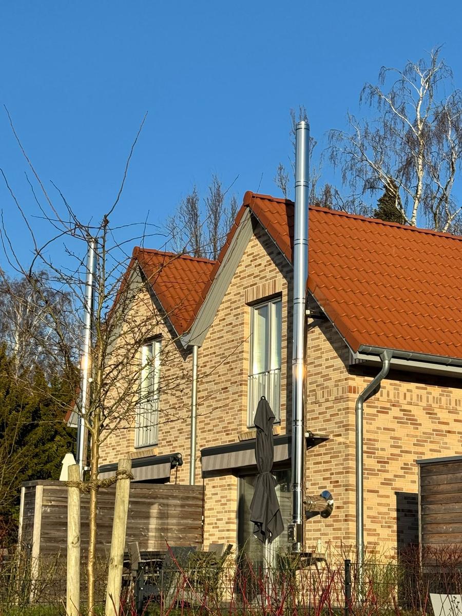 Haus mit rotem Dach, braunen Ziegeln und geschlossener Terrassenmarkise.