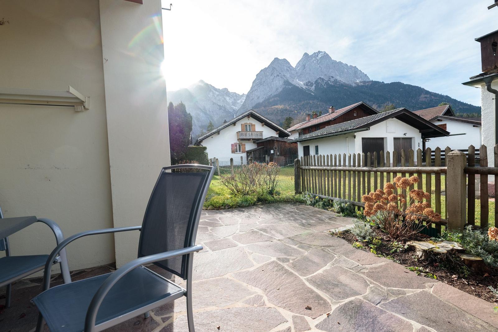 Terrasse mit Sitzgelegenheit, Blick auf Berge und traditionelle Häuser.