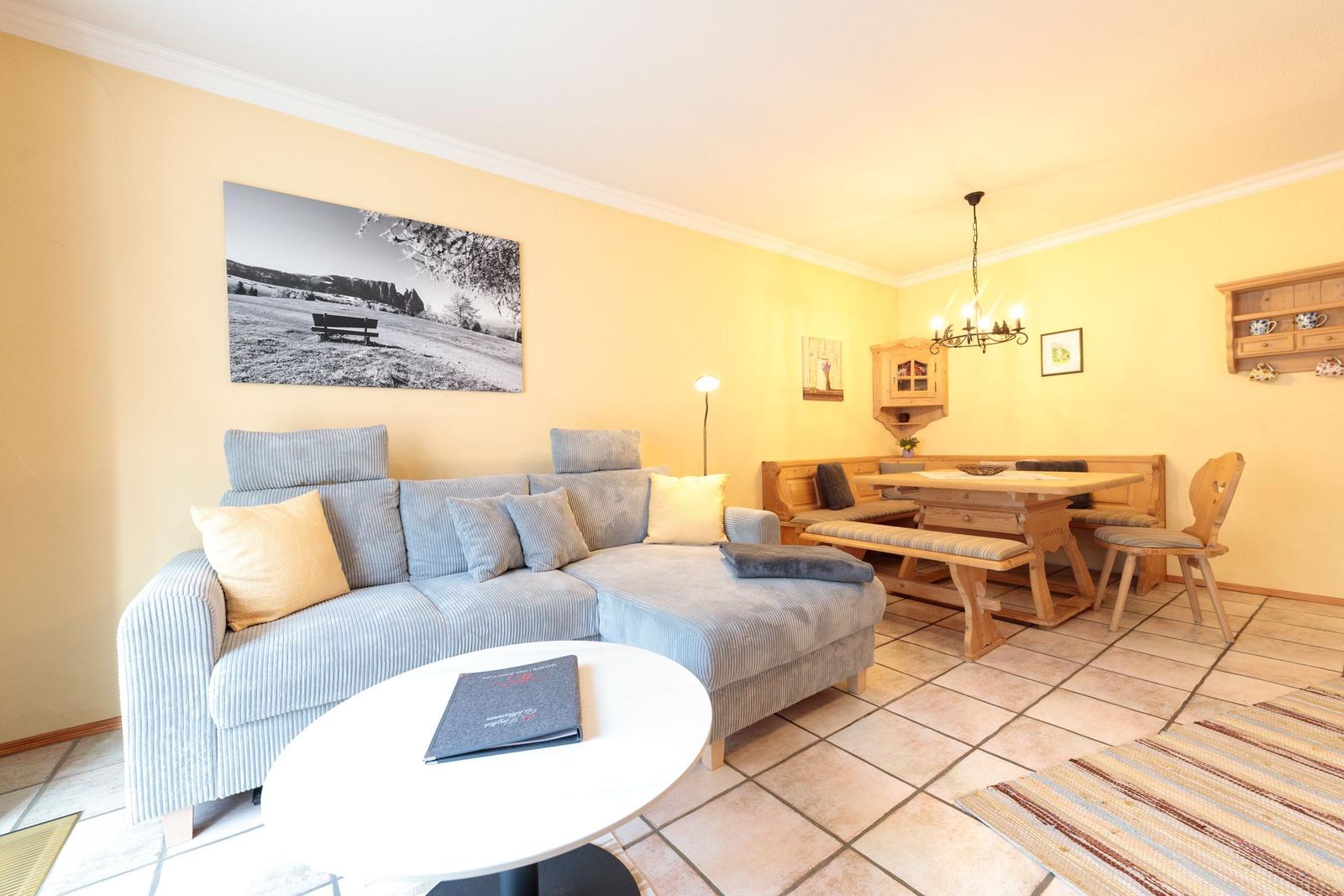 Wohn- und Essbereich mit Sofa, Esstisch und Holzmöbel.