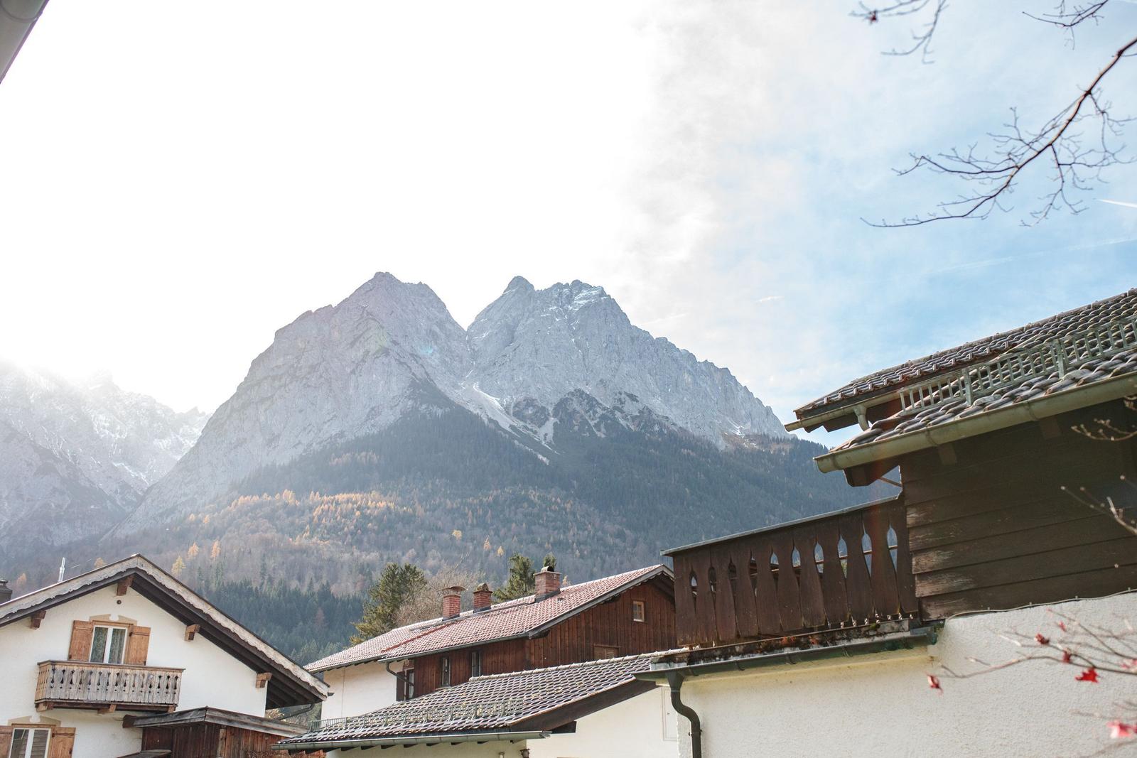 Haus mit Blick auf schneebedeckte Berge und Wald.