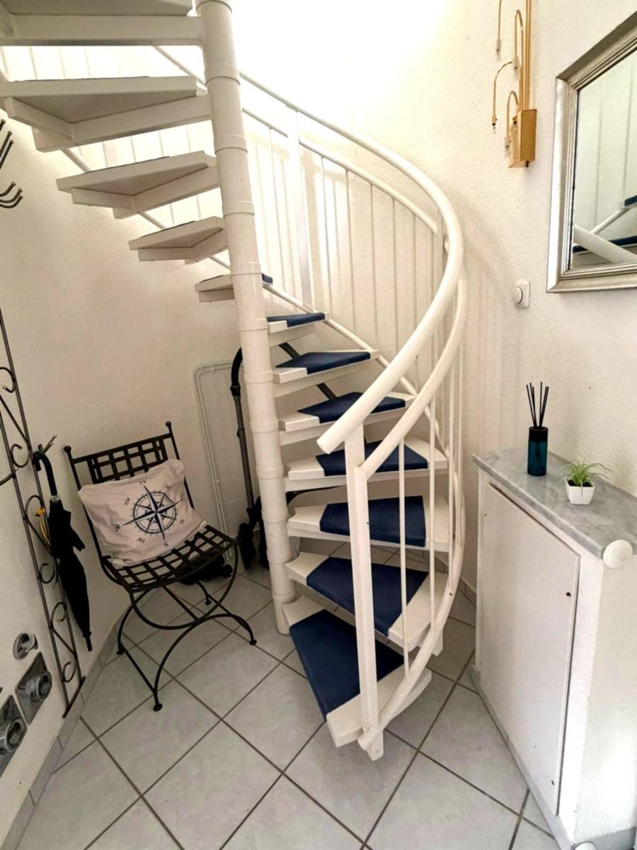 Wohnung mit Wendeltreppe, Stuhl und Spiegelfläche an der Wand.