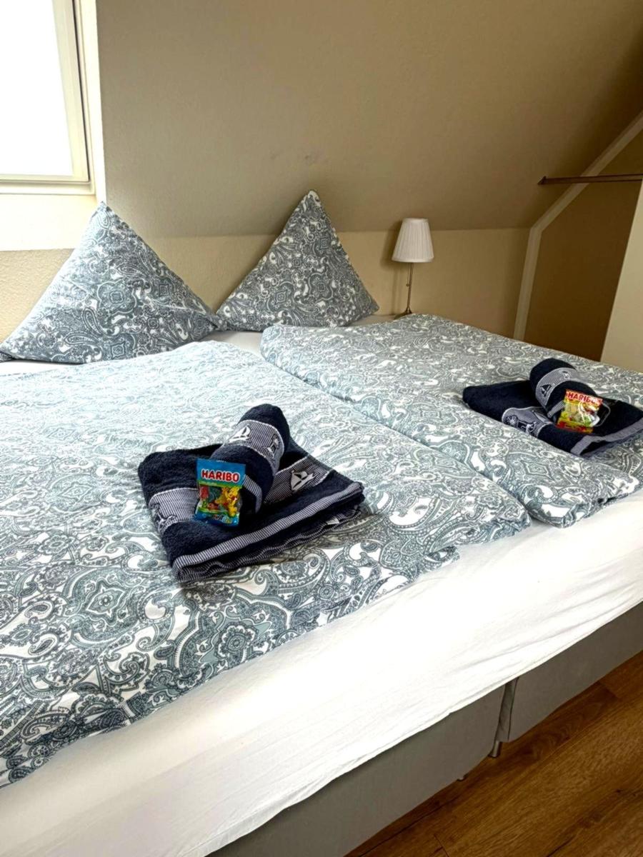 Schlafzimmer mit Doppelbett, gemusterten Kissen und Handtüchern auf dem Bett.