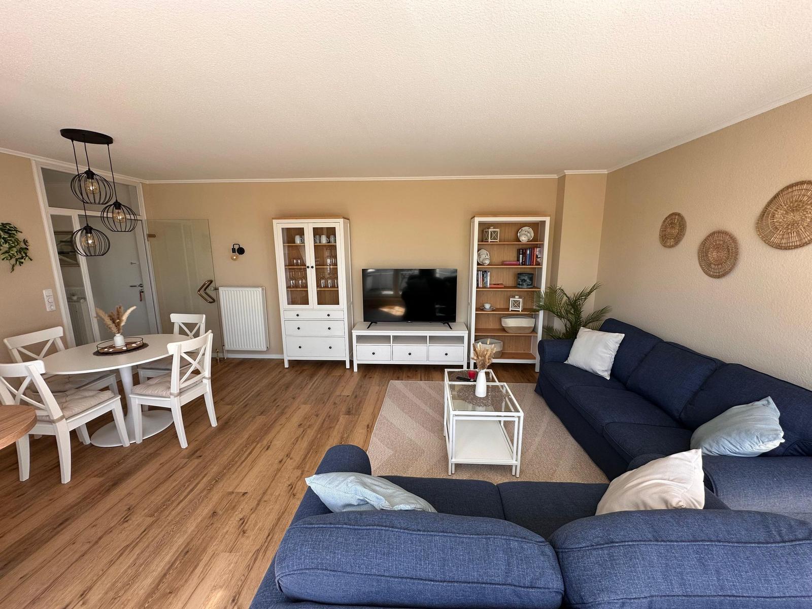 Wohn- und Essbereich mit Sofa, TV und Esstisch.