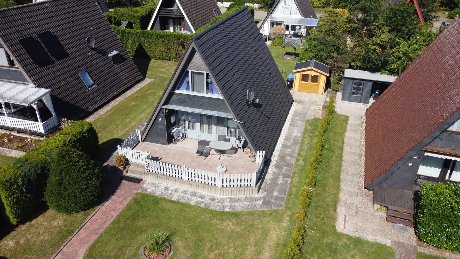 Atriumhaus mit Terrasse, Garten und Grillplatz. Umgeben von grüner Landschaft.