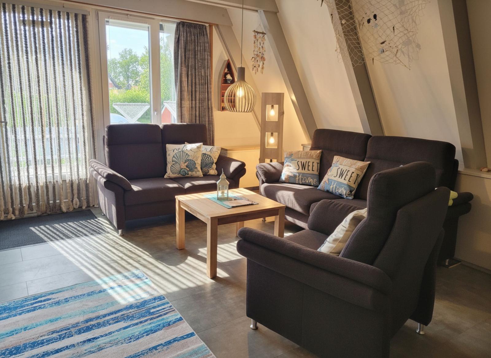 Wohnzimmer mit zwei Sofas, einem Beistelltisch und Fensterblick.