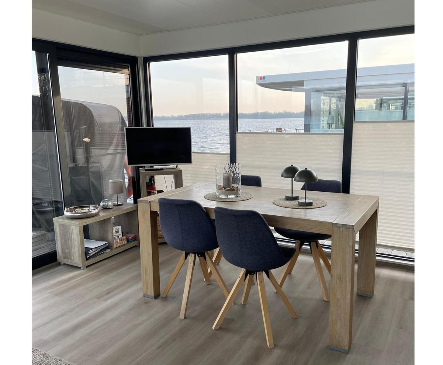 Esszimmer mit Tisch, Stühlen und Blick auf Wasser
